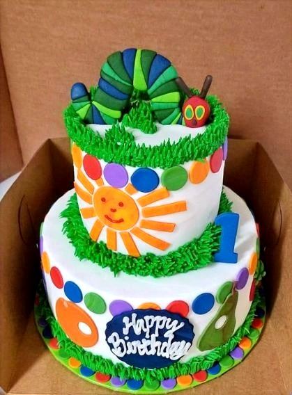 Bright layered birthday cake with flowers and a Happy Birthday topper