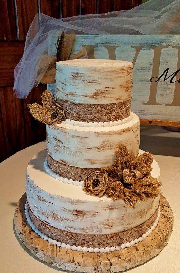 Semi-naked wedding cake with sunflowers, burlap and a monogram topper