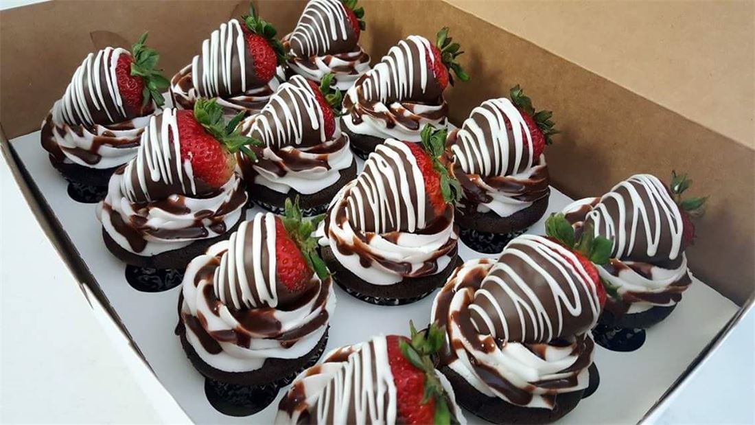 Tray of chocolate covered strawberries with white drizzle