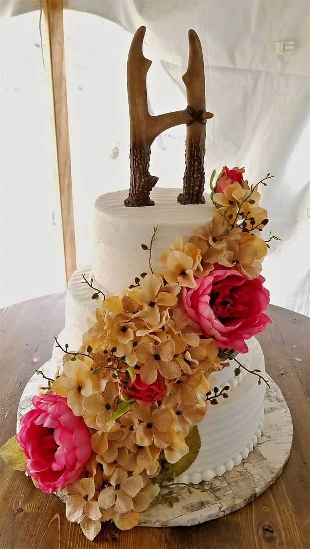 Wedding cake with a cascade of gold and peach flowers