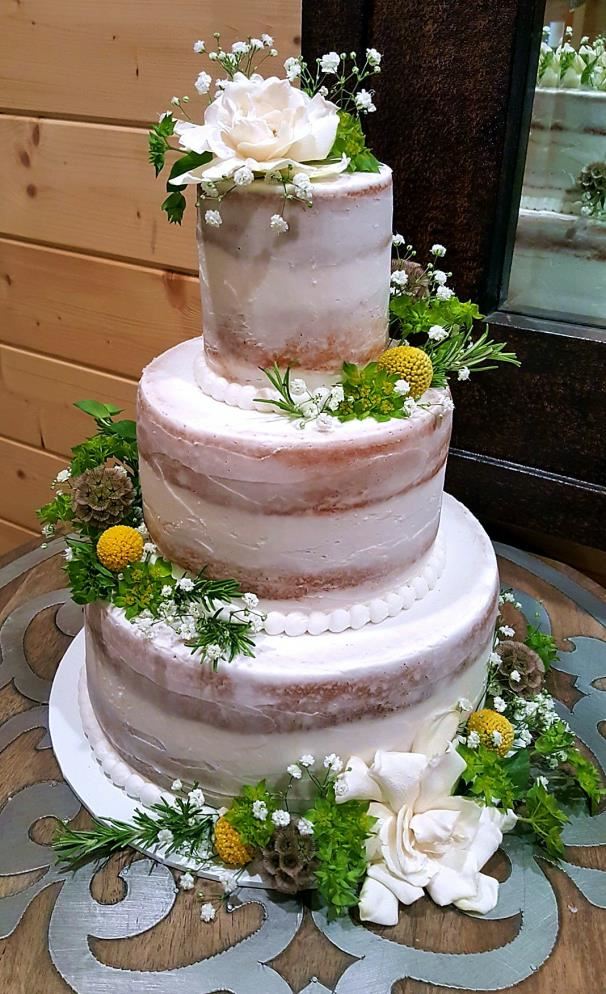 Semi-naked cake with blush flowers and trailing greenery
