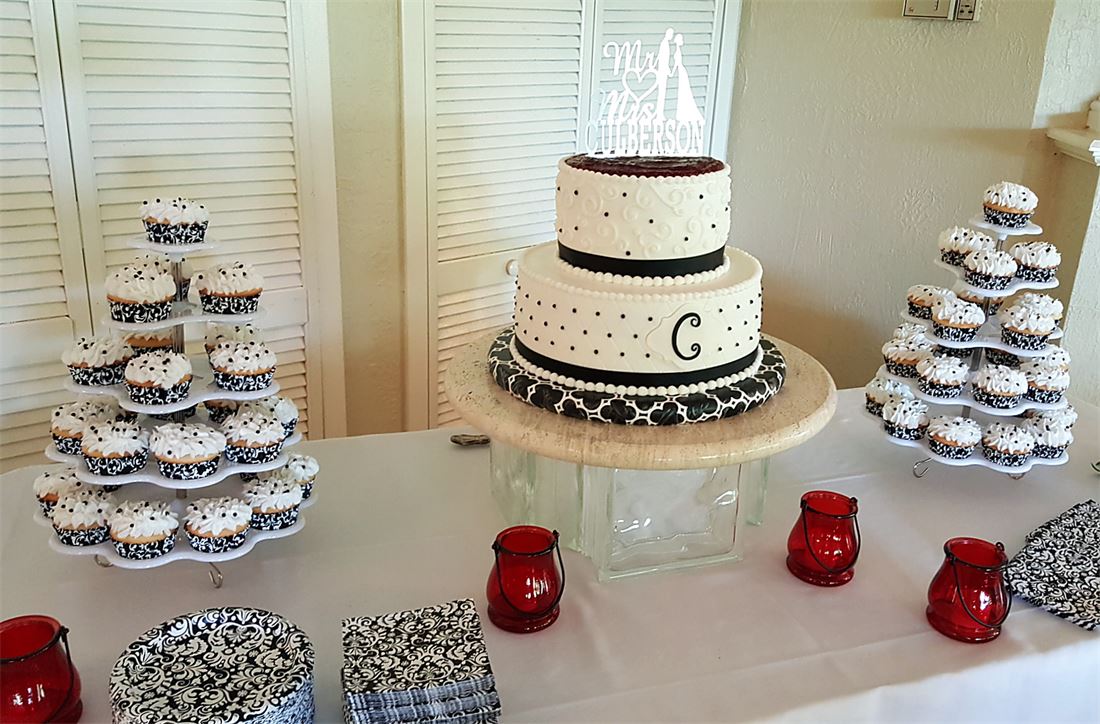 Cupcake tower beside a black and white monogram cake