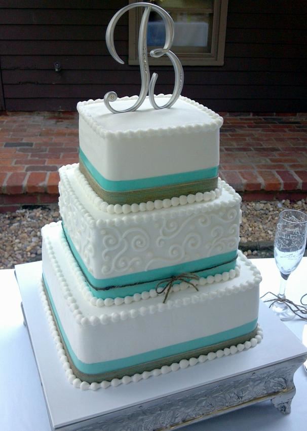 Square teal and white tiered cake with a monogram topper