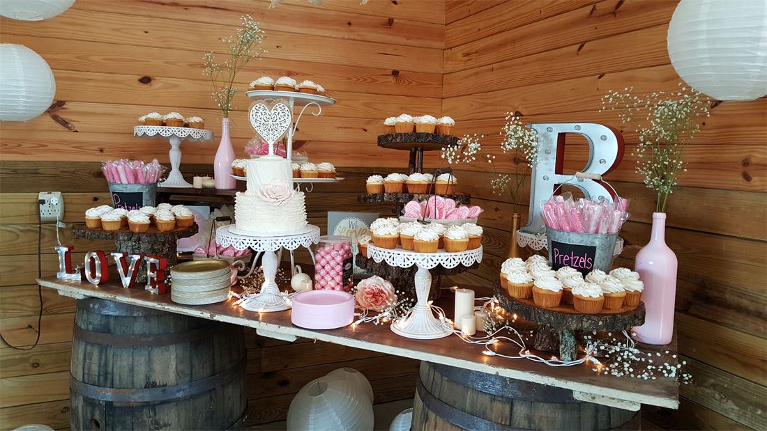 Dessert table of assorted treats with a lettered backdrop