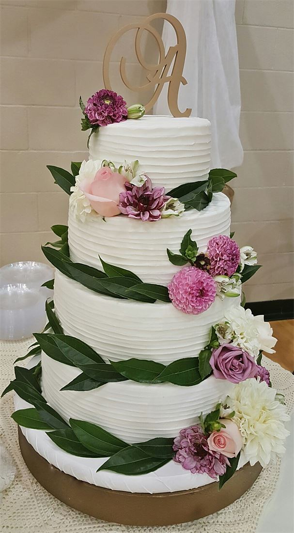 Naked cake with greenery and pink blooms